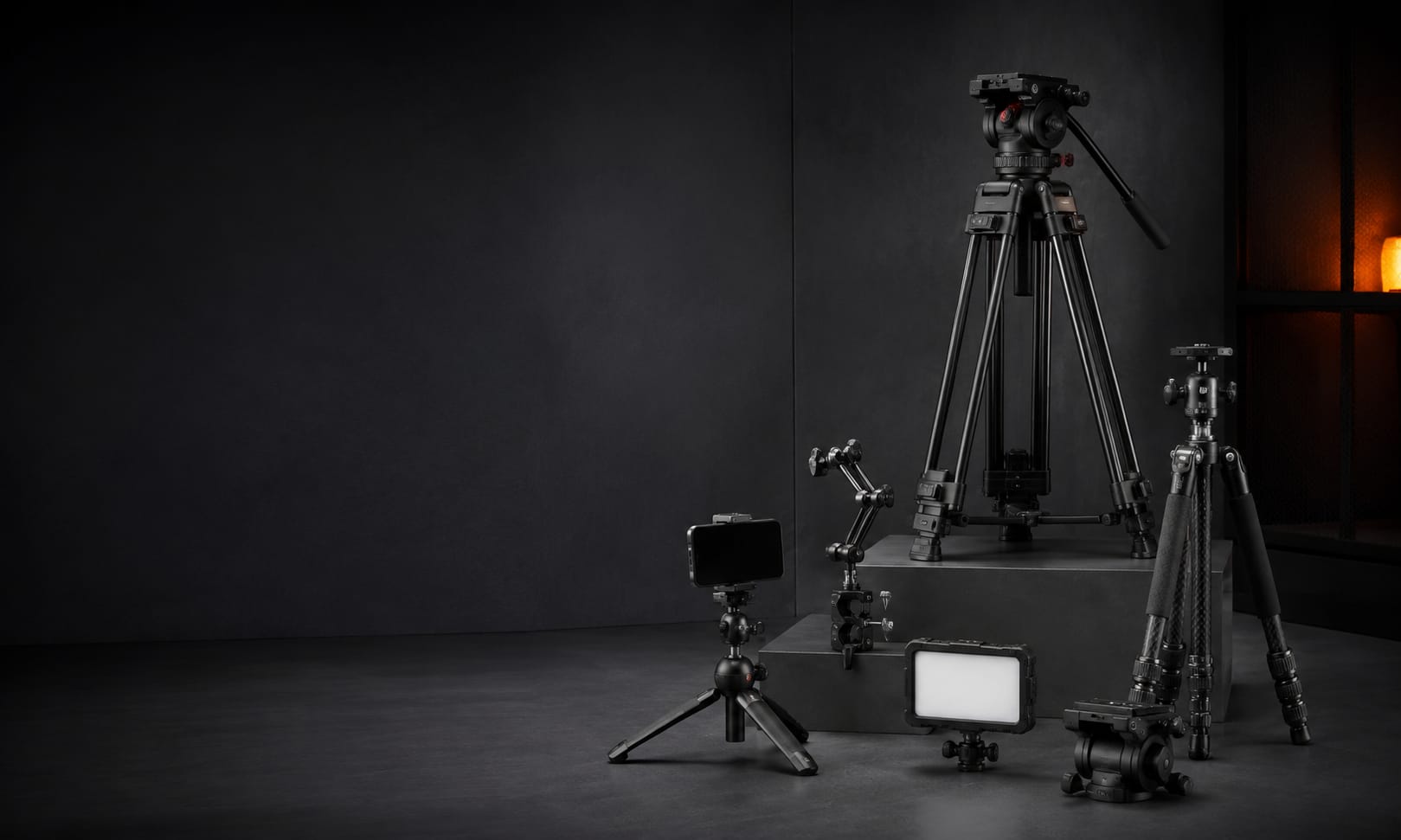 Professional tripods, camera heads, mobile support, and production lighting in a studio