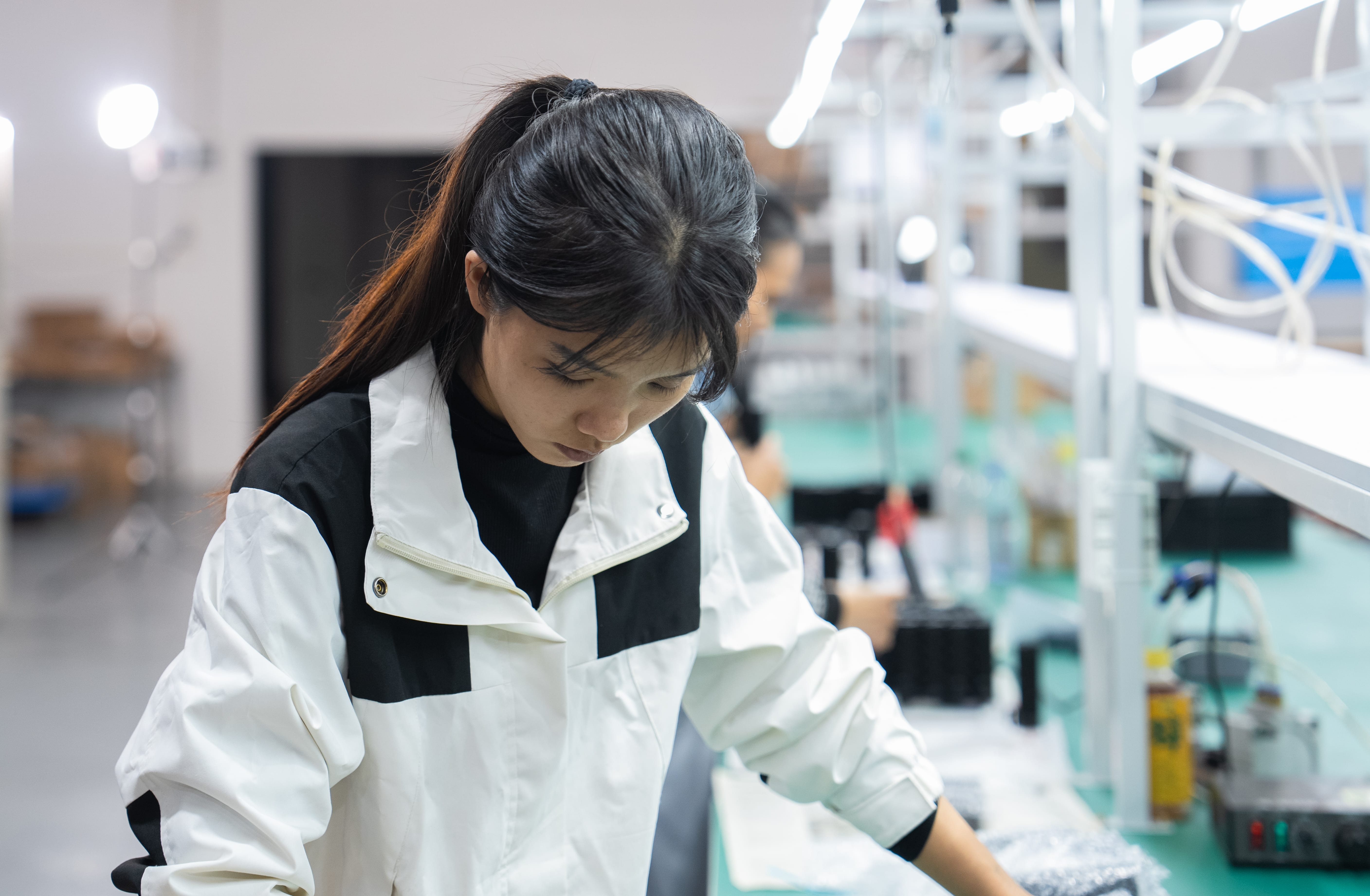 OGLemon team member focused on component assembly at a production station