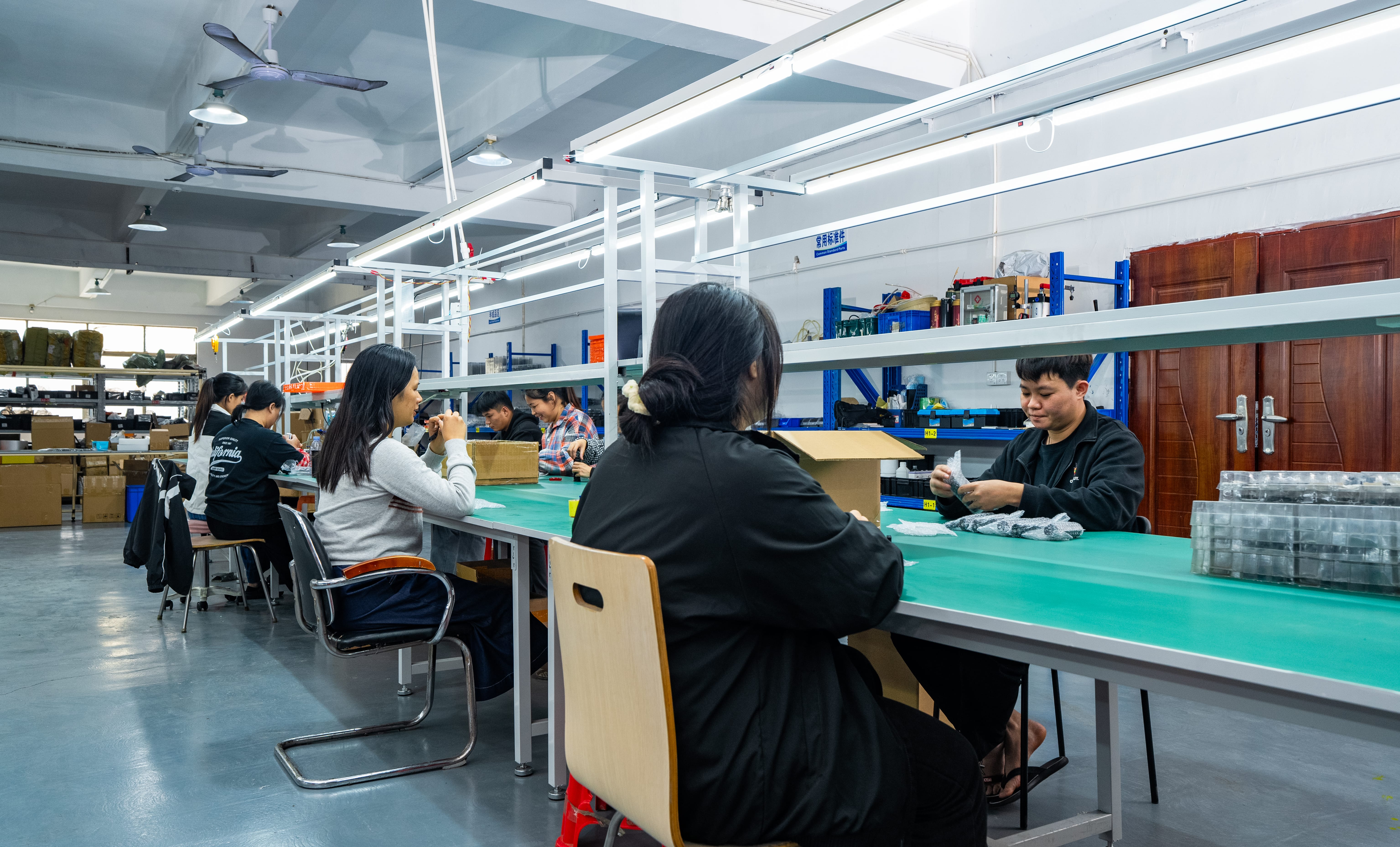 OGLemon production team assembling components together at a shared workbench