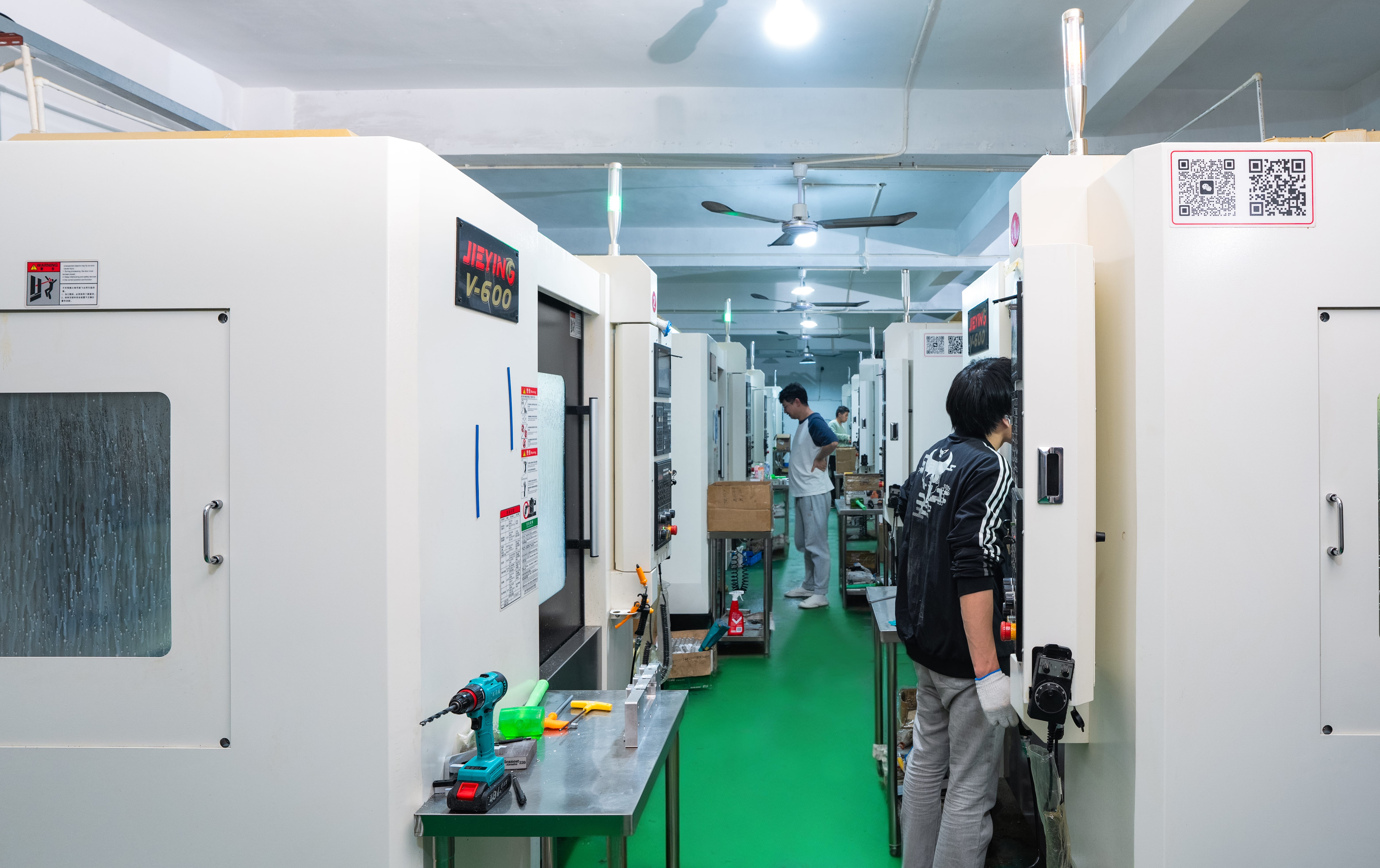 CNC machining center aisle with technicians at work