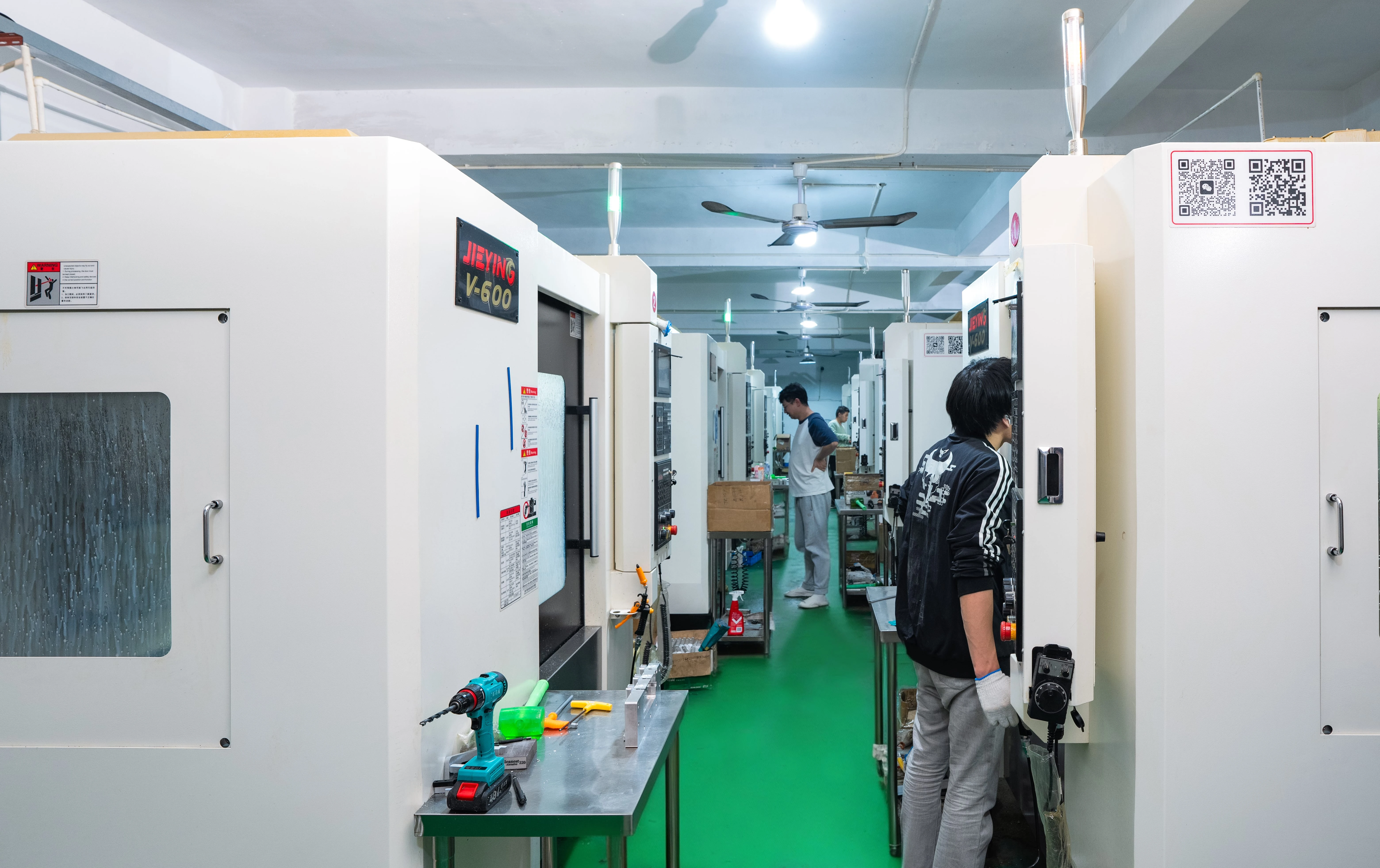 CNC machining center aisle with technicians at work