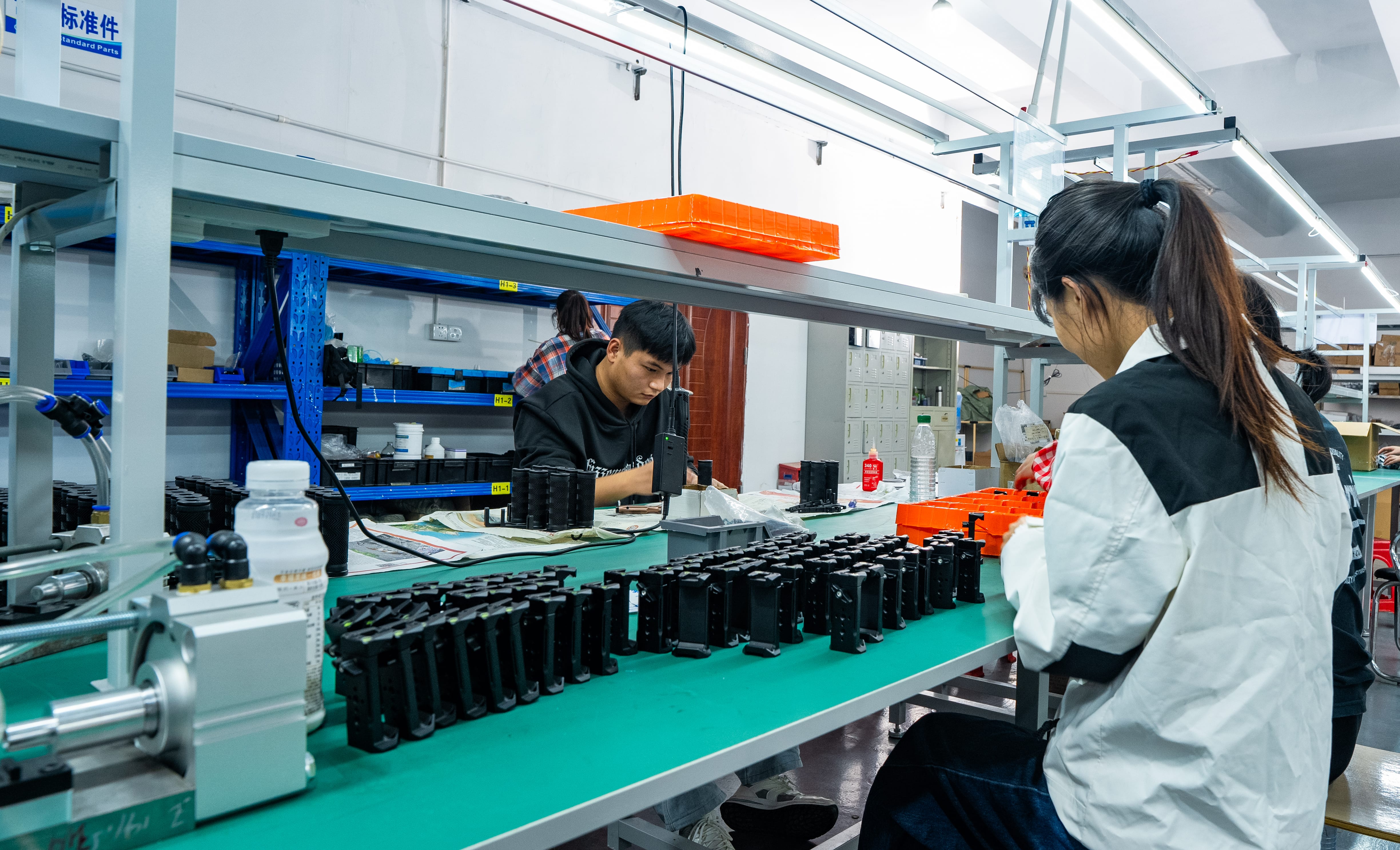 OGLemon production team assembling camera support components at a workbench
