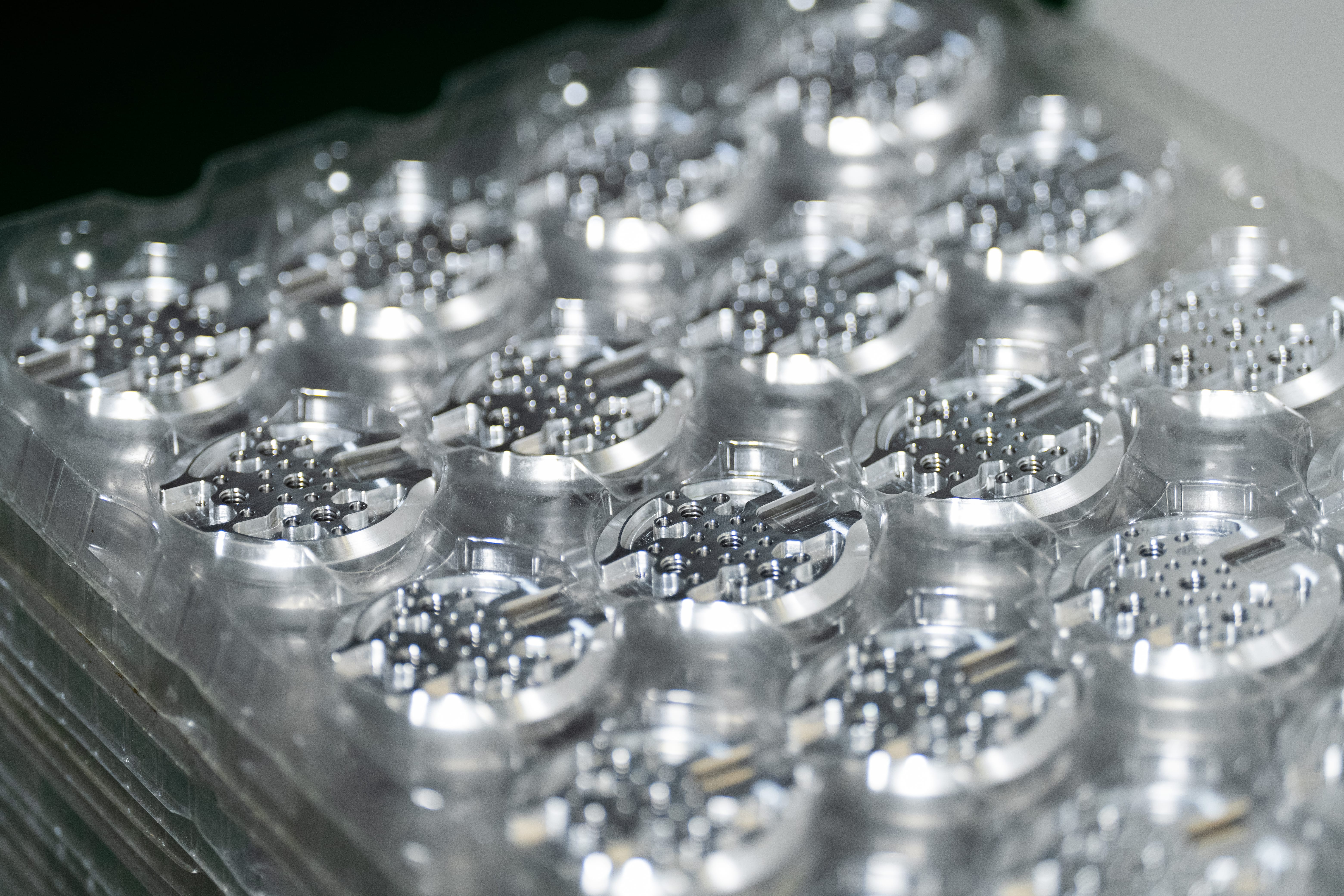 Trays of CNC-machined aluminum camera support components