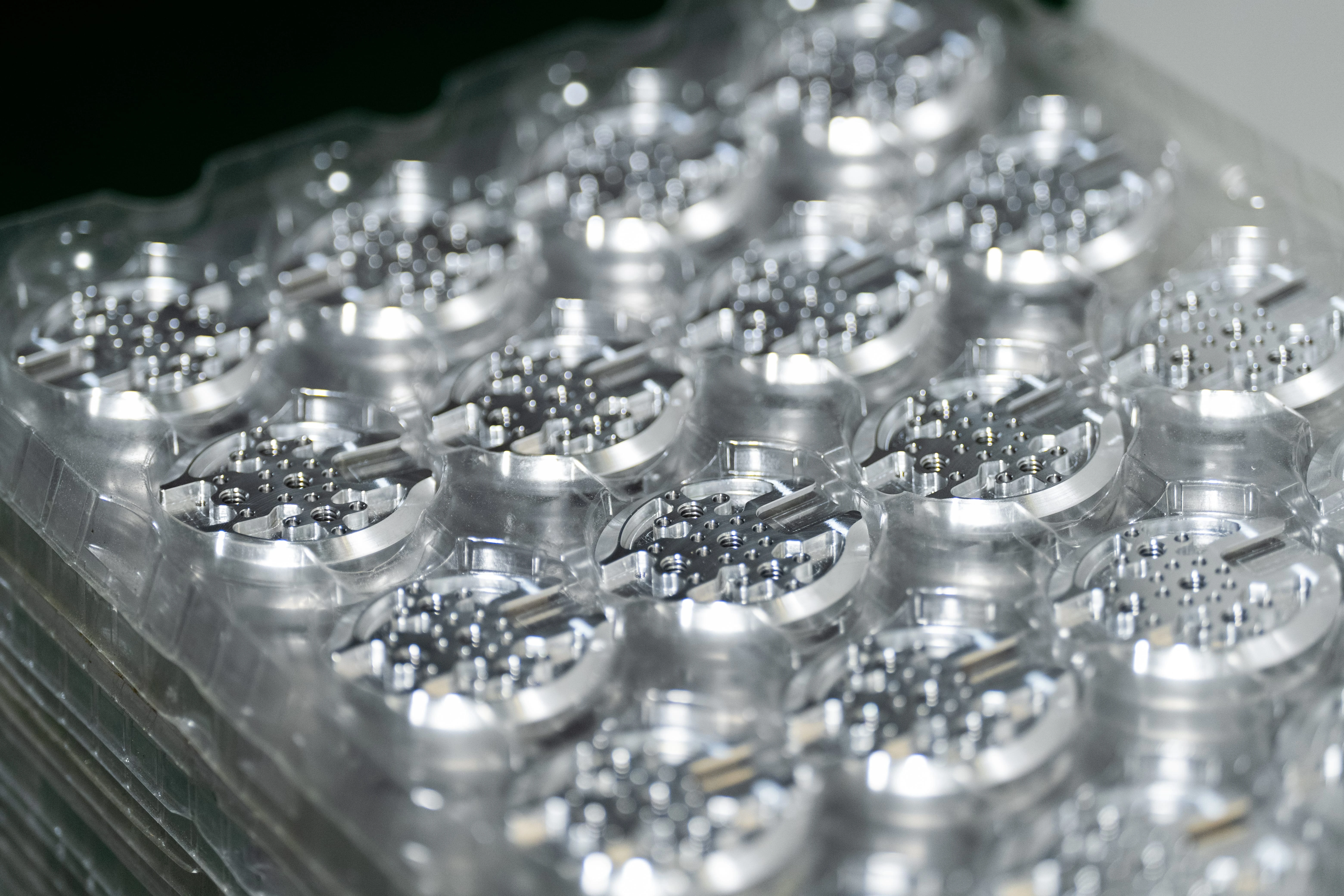 Trays of CNC-machined aluminum camera support components