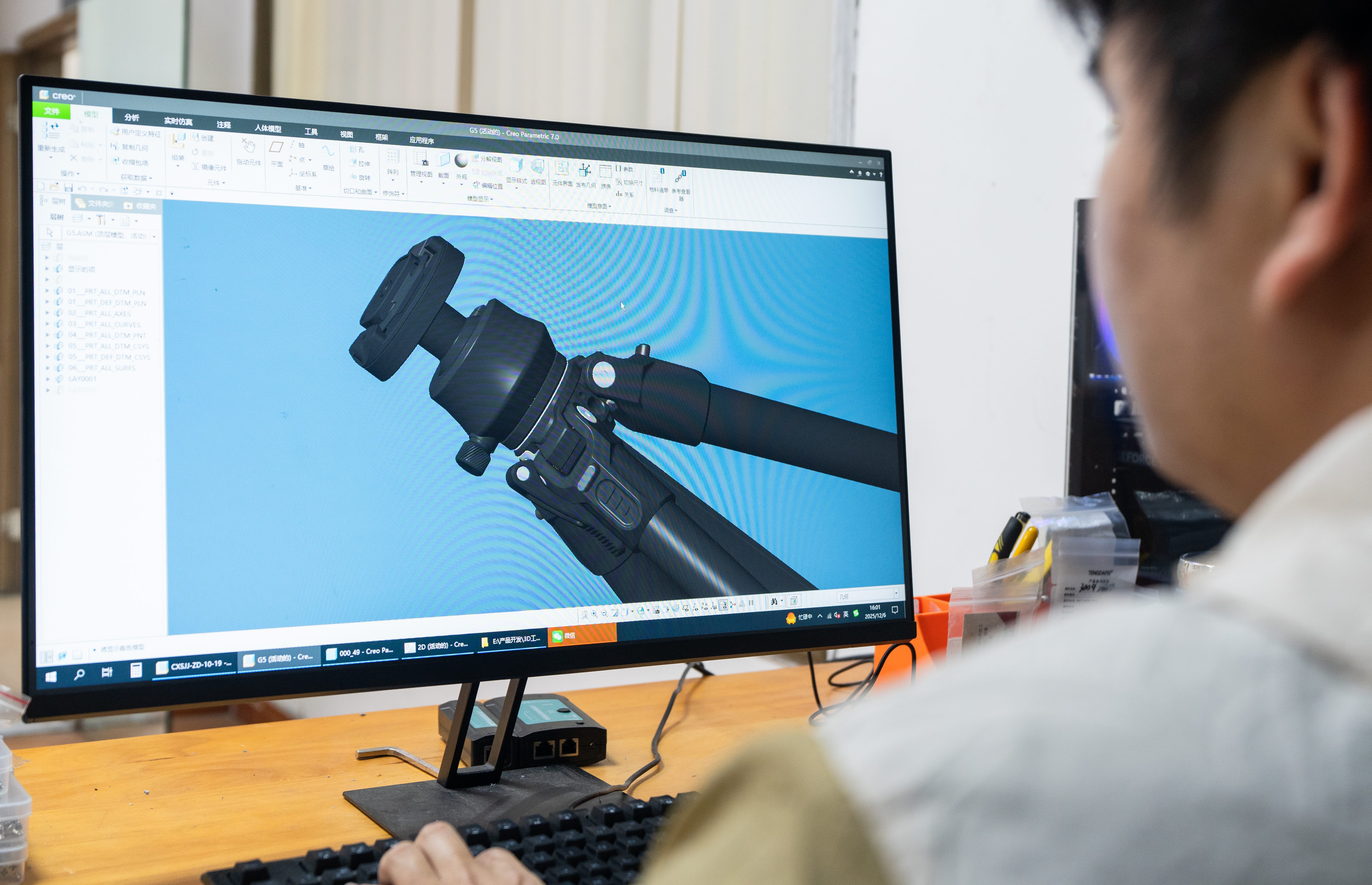 Engineer reviewing a camera support assembly in CAD software